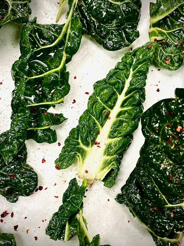 Crispy baked silverbeet chips seasoned with chilli and sea salt on a tray